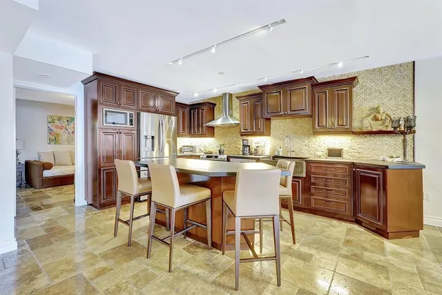 a kitchen with stainless steel appliances granite countertop a refrigerator and a stove top oven