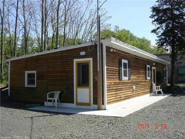 a view of a house with backyard and trees