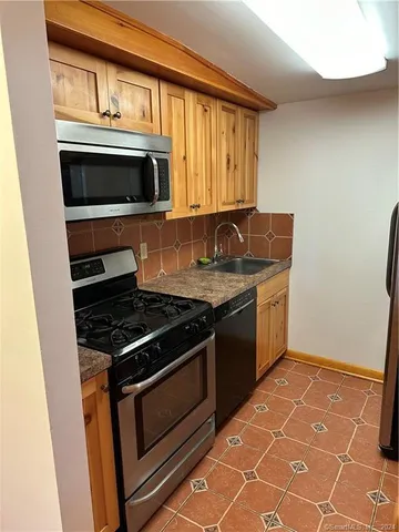 a kitchen with granite countertop a stove top oven microwave and cabinets