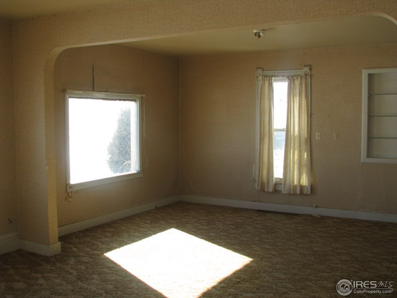 8381 East County Line Road Longmont, CO 80504 - Photo 12 of 18 an empty room with wooden floor and windows