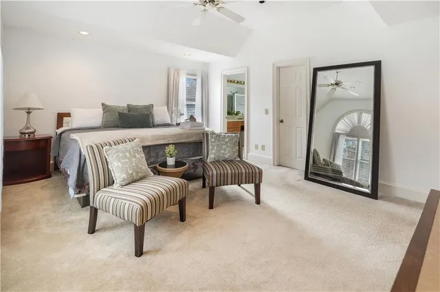 a spacious bedroom with a bed and a flat screen television