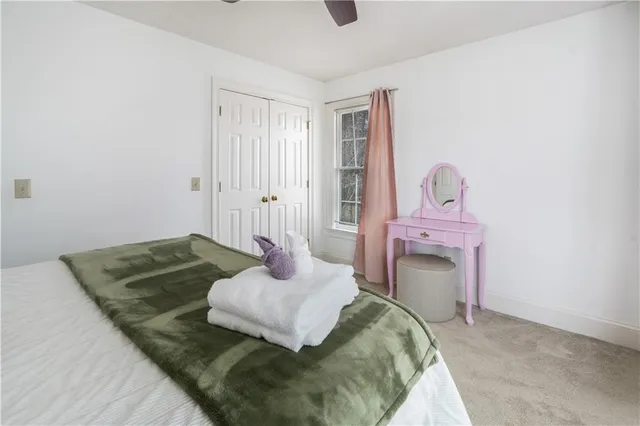 a bedroom with a bed lamp and a large window