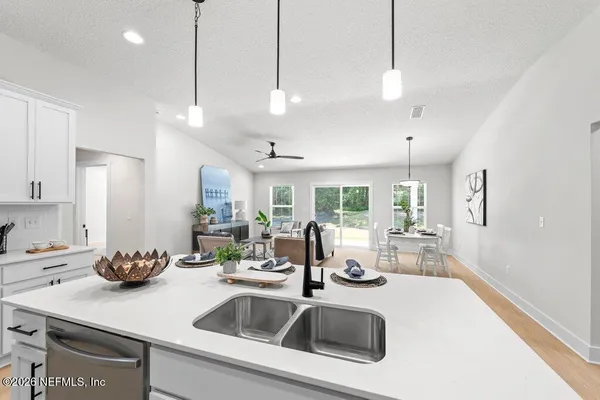 a kitchen with counter top a sink appliances and cabinets