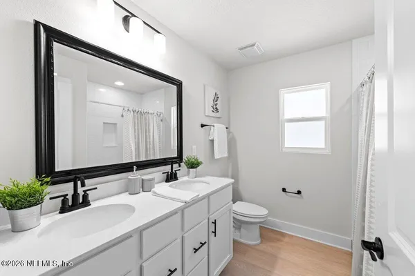 a bathroom with a double vanity sink and a mirror