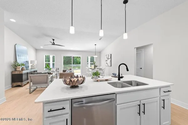 a kitchen with a sink and living room view