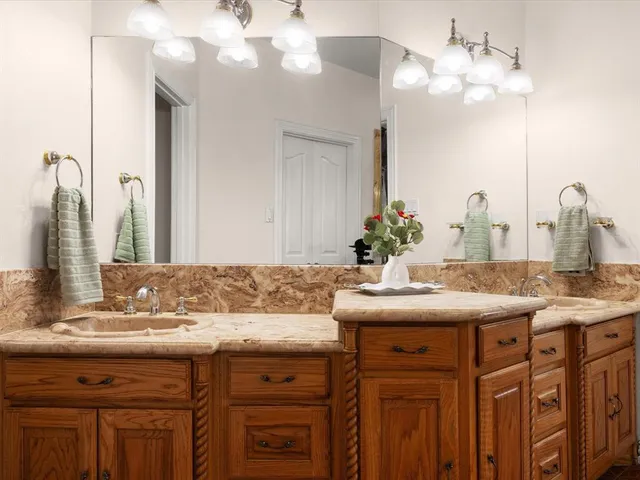 a bathroom with a granite countertop sink and a mirror