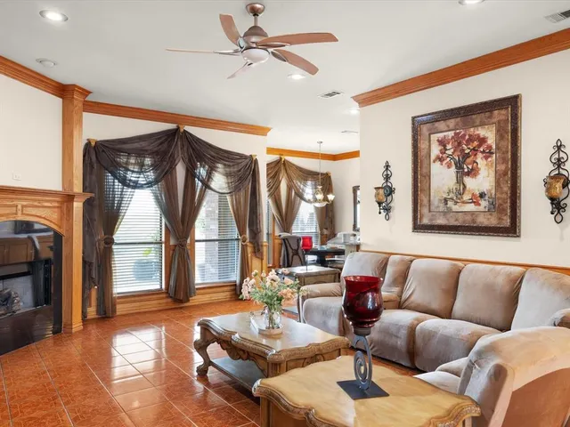 a living room with furniture a large window and a chandelier