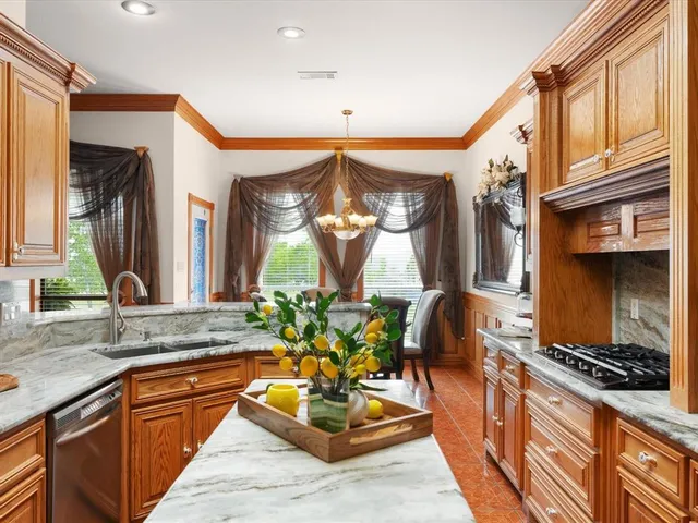a kitchen with stainless steel appliances granite countertop a stove a sink and a refrigerator