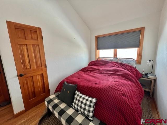 64130 Peach Valley Road Crawford, CO 81415 - Photo 24 of 33 a bedroom with a bed and wooden floor