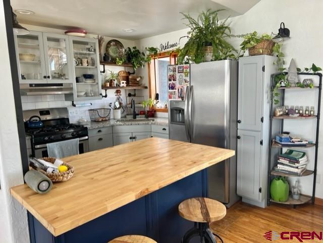 64130 Peach Valley Road Crawford, CO 81415 - Photo 7 of 33 a kitchen with stainless steel appliances kitchen island granite countertop a refrigerator a stove and a wooden floors