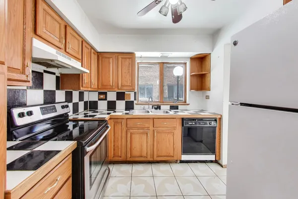 a kitchen with stainless steel appliances granite countertop a stove a sink and a refrigerator