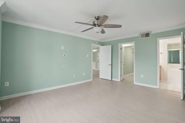 a view of an empty room and a ceiling fan