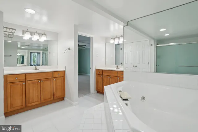 a spacious bathroom with a tub sink and mirror
