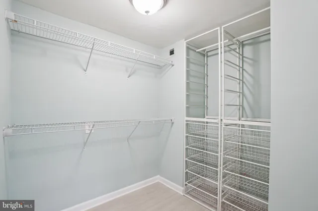 a view of walk in closet with empty racks