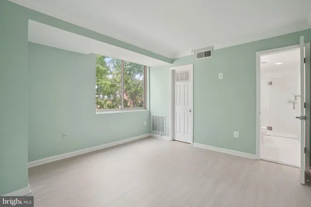 an empty room with windows and closet area