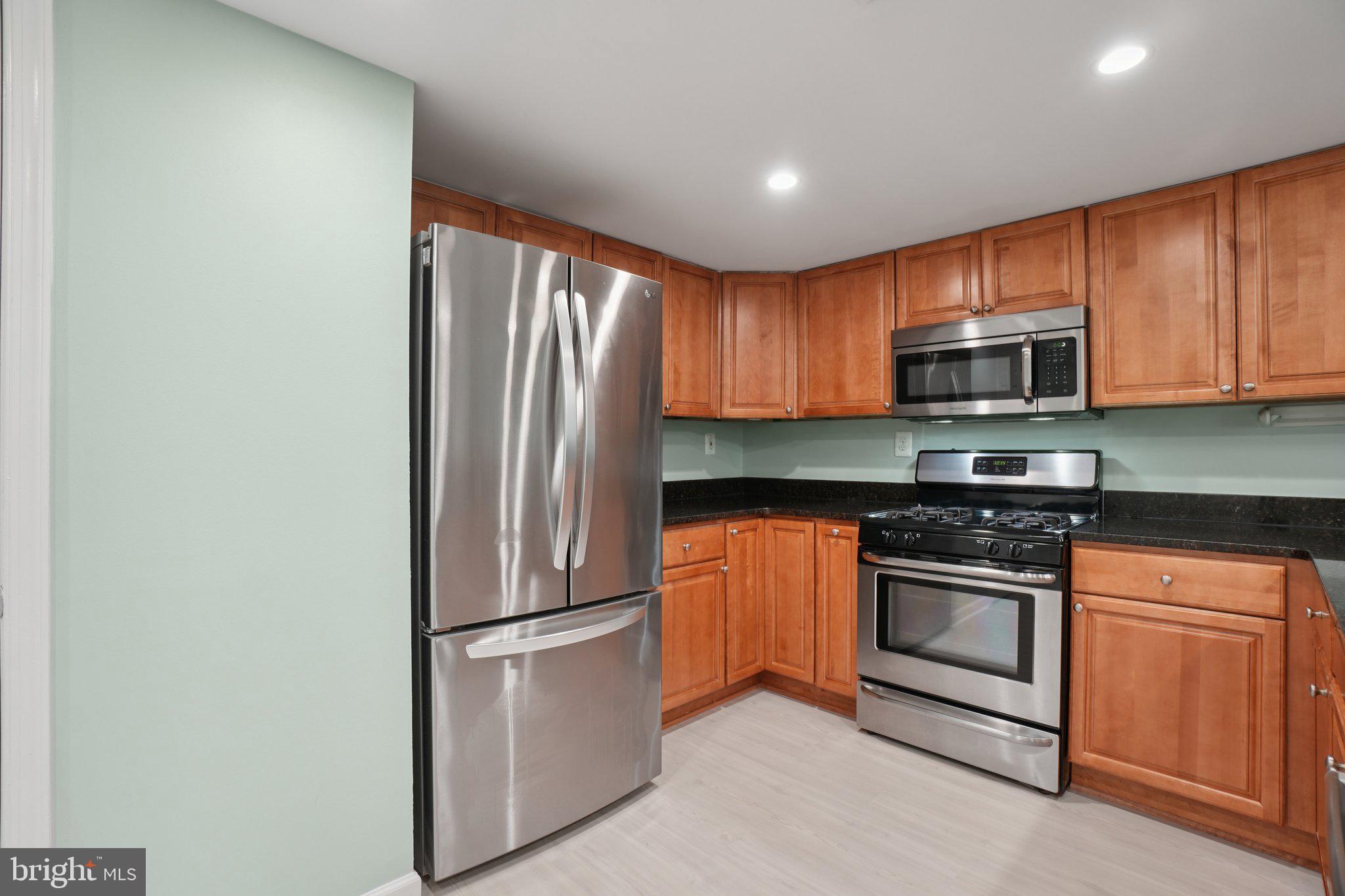 1515 South Arlington Ridge Road, Unit 603 Arlington, VA 22202 - Photo 8 of 39 a kitchen with stainless steel appliances granite countertop a refrigerator stove a sink and microwave