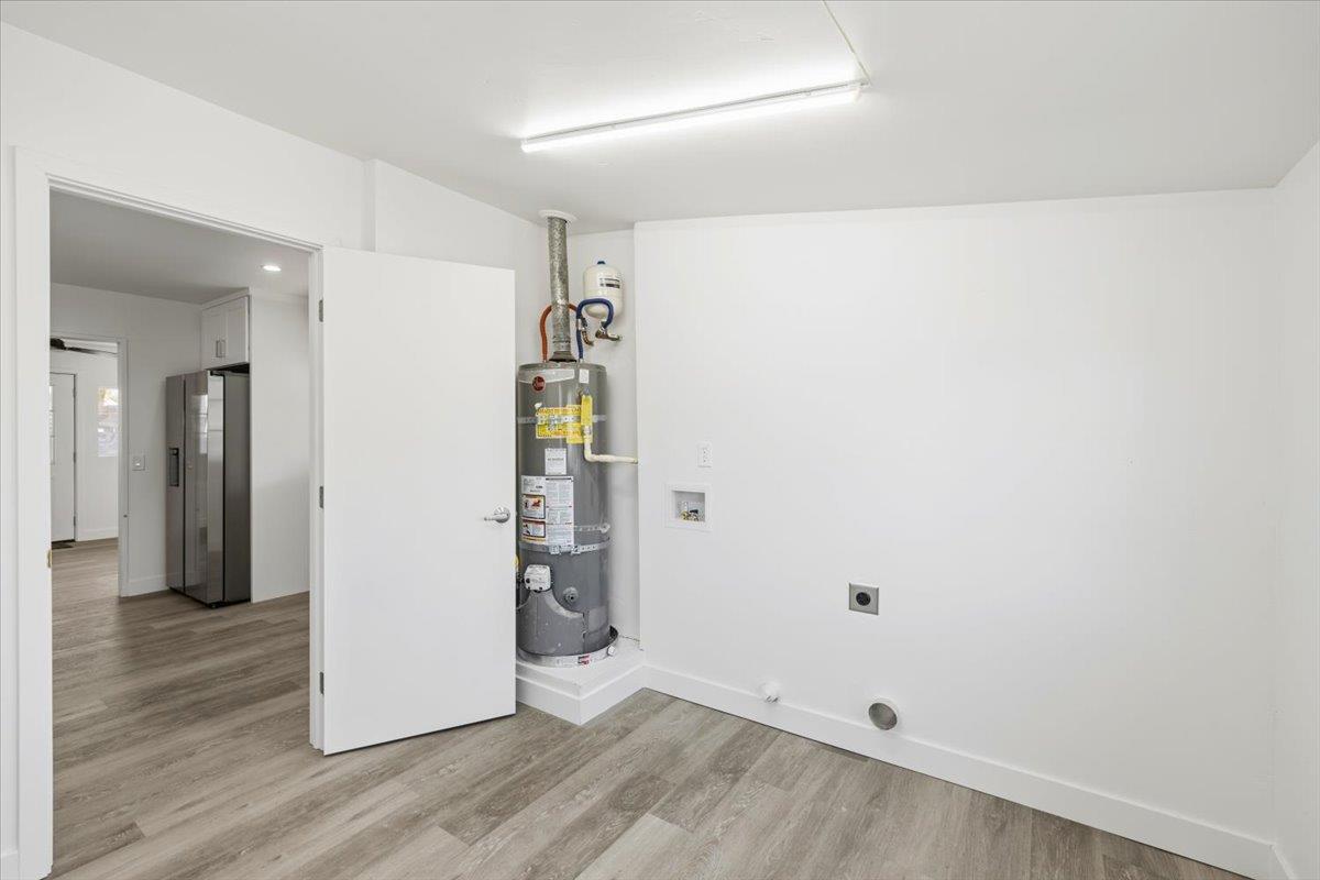 209 Dewitt Court Sacramento, CA 95838 - Photo 17 of 25 laundry room featuring hookup for a washing machine, light wood finished floors, strapped water heater, and electric dryer hookup