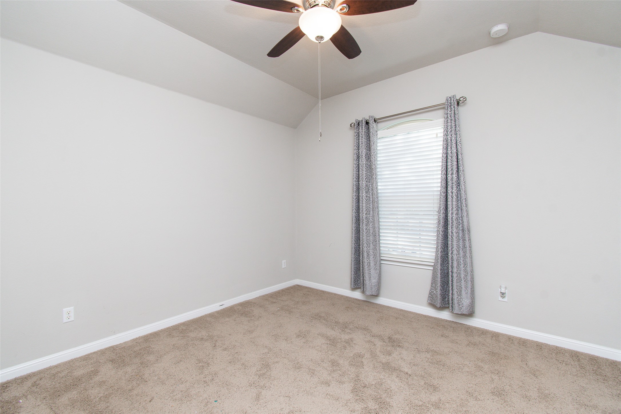 136 Mistflower Lane Kyle, TX 78640 - Photo 15 of 20 an empty room with a chandelier fan and windows