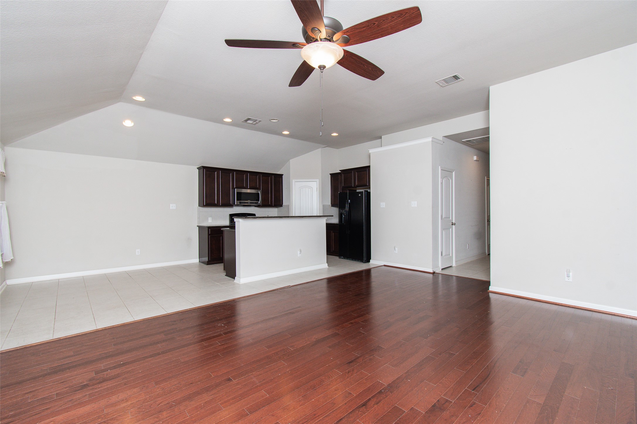 136 Mistflower Lane Kyle, TX 78640 - Photo 4 of 20 a view of a kitchen with a microwave and wooden floor