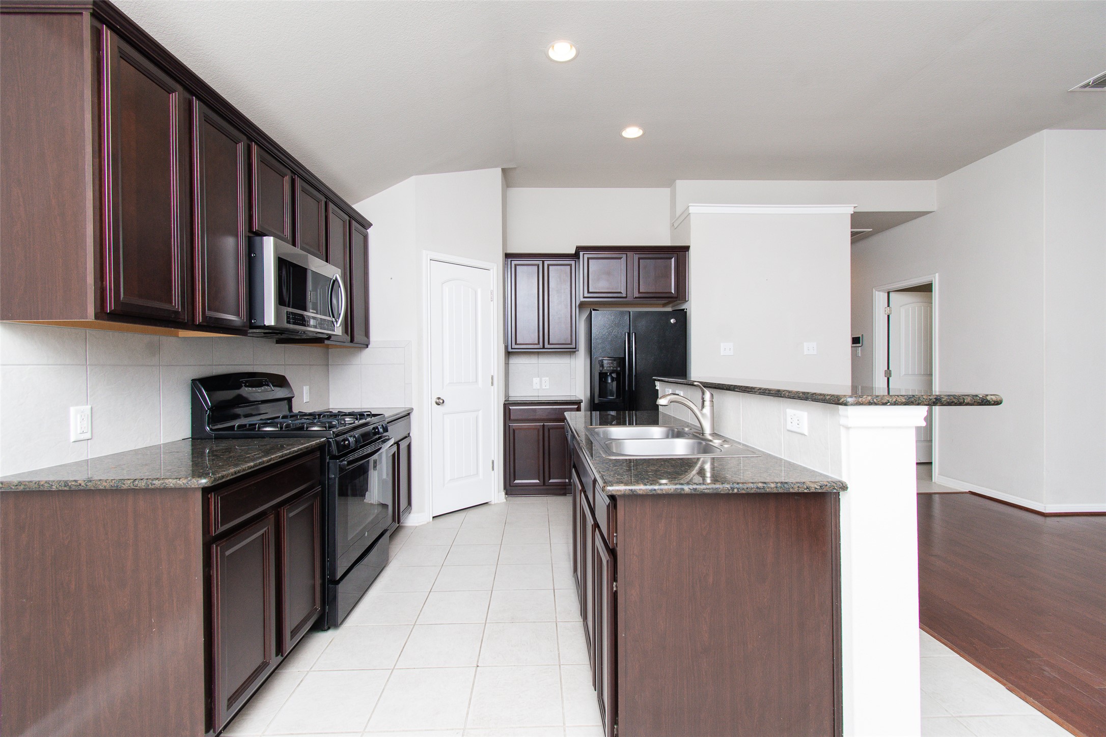 136 Mistflower Lane Kyle, TX 78640 - Photo 6 of 20 a kitchen with kitchen island granite countertop a sink stove and refrigerator