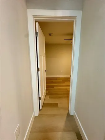 a view of a hallway with wooden floor and a hallway