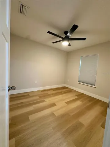 a view of a room with wooden floor and ceiling fan