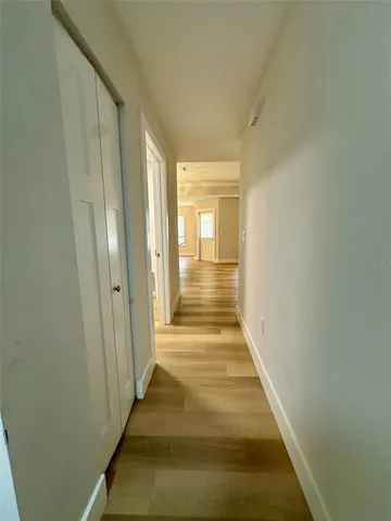 a view of a hallway with wooden floor and staircase