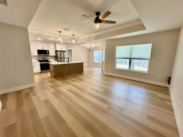 a large kitchen with cabinets wooden floor and stainless steel appliances