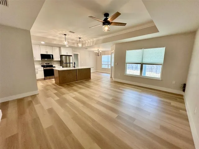 a large kitchen with cabinets wooden floor and stainless steel appliances