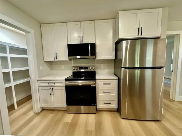 a kitchen with stainless steel appliances a refrigerator stove and microwave