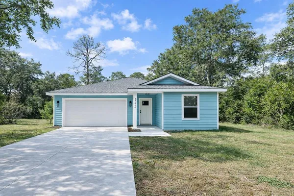 a front view of a house with yard and trees