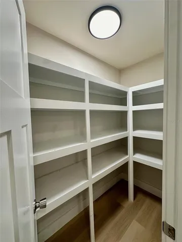a view of walk in closet with empty racks