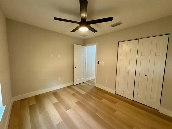 a view of empty room with wooden floor