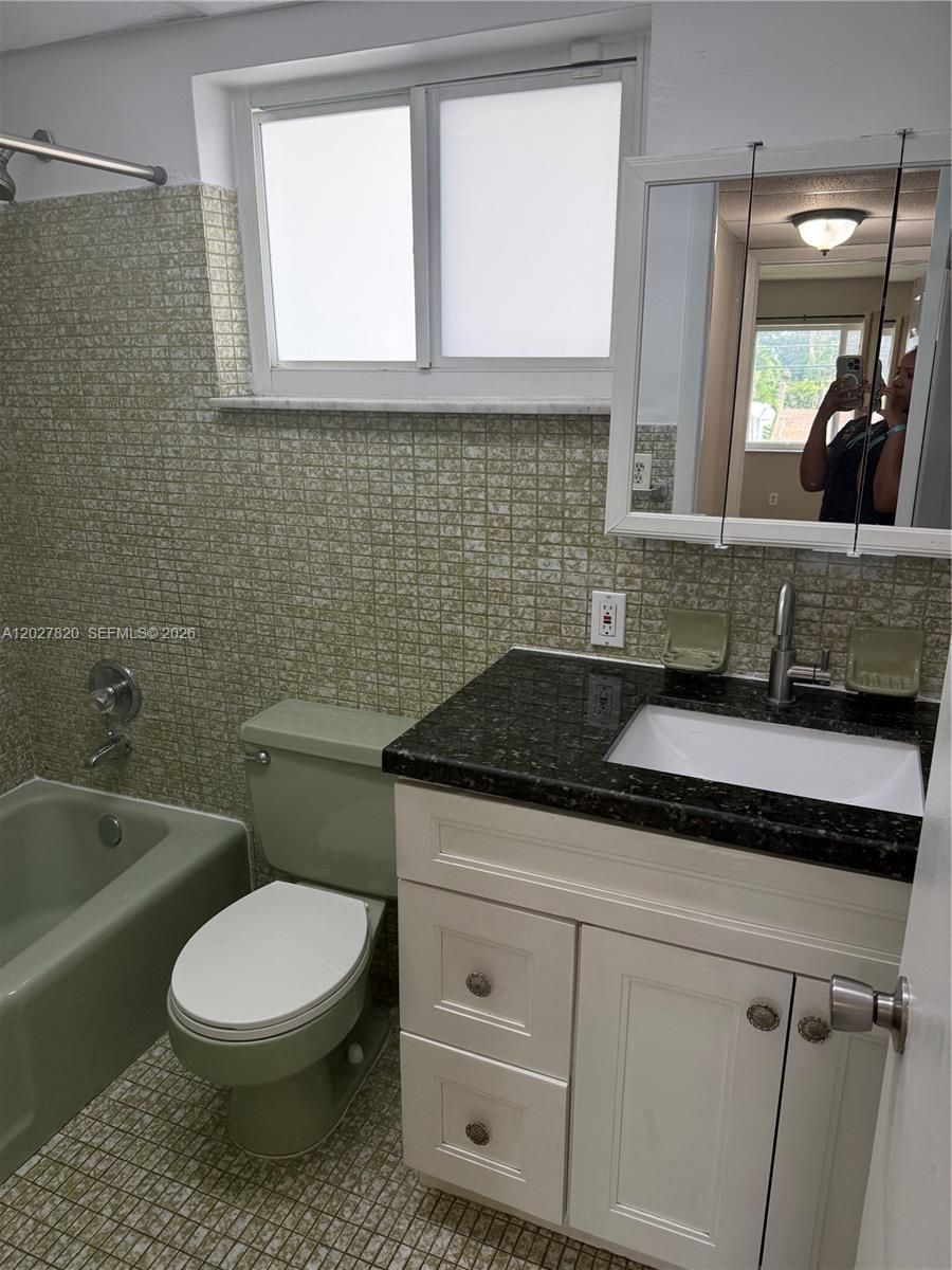 6841 Pembroke Road, Unit 15 Pembroke Pines, FL 33023 - Photo 10 of 16 a bathroom with a granite countertop toilet sink and mirror