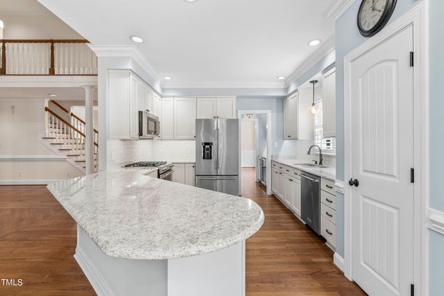 a kitchen with kitchen island a counter top space a sink stainless steel appliances and cabinets