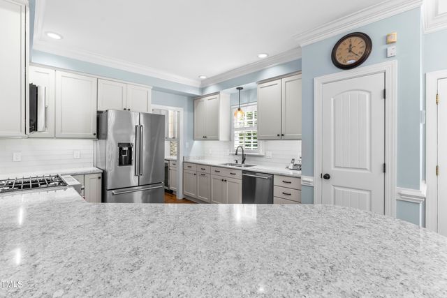 a large kitchen with a stove a refrigerator and a sink