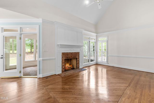 a view of empty room with wooden floor and fireplace