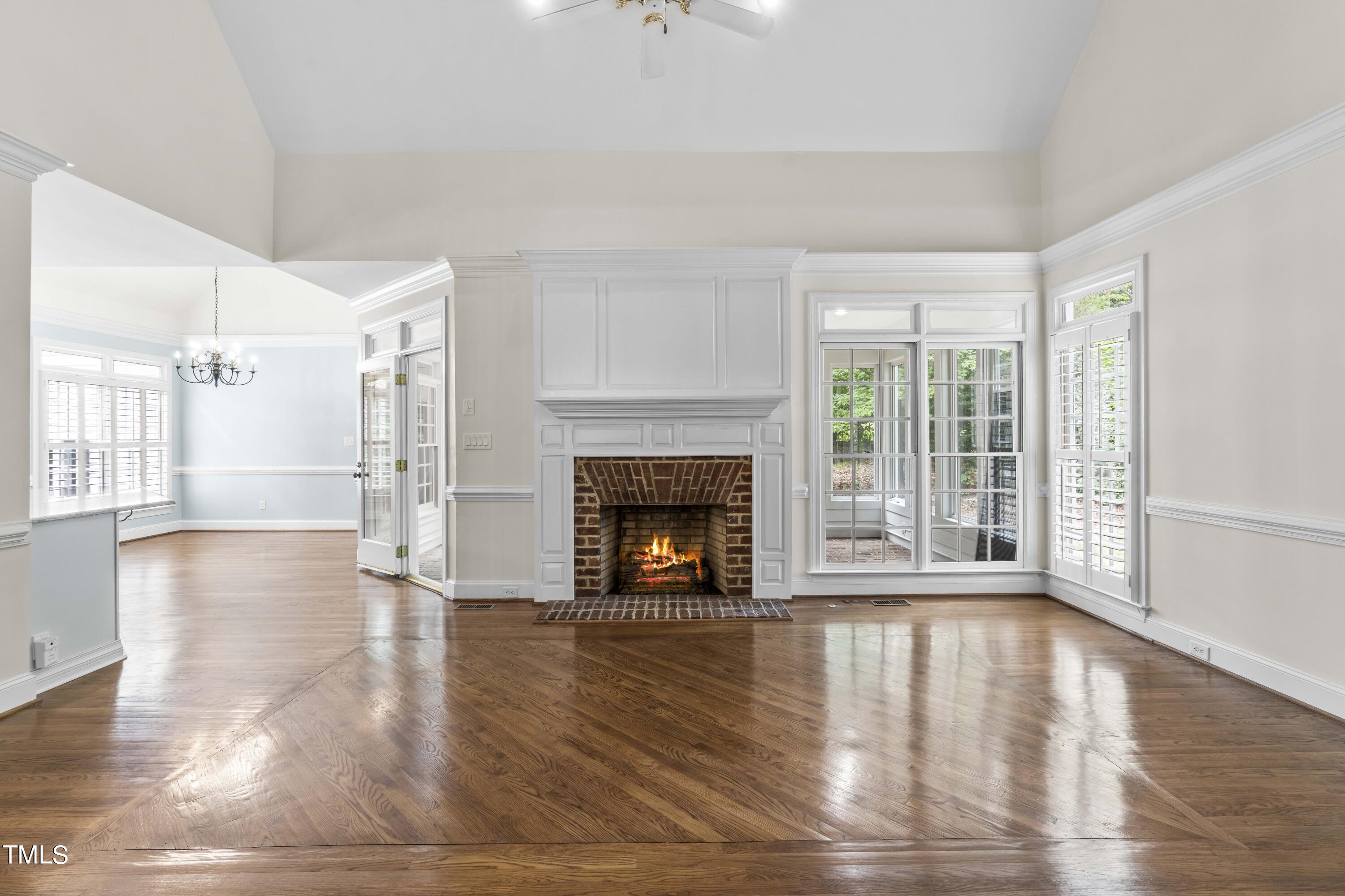 1556 Crenshaw Point Wake Forest, NC 27587 - Photo 18 of 46 a view of an empty room with wooden floor fireplace and a window