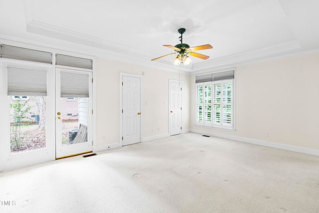 an empty room with windows and fan