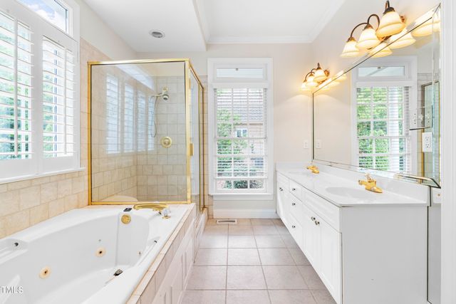 a bathroom with a bathtub a double vanity and windows