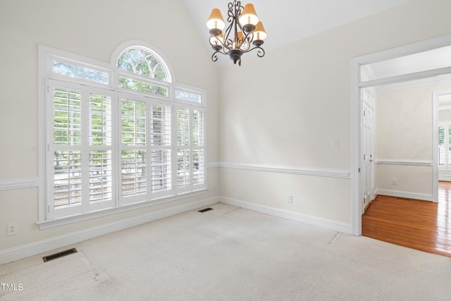 en empty room with windows and chandelier