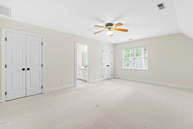 an empty room with a window and a ceiling fan