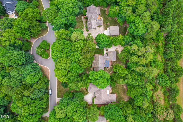 an aerial view of a house with a yard and trees