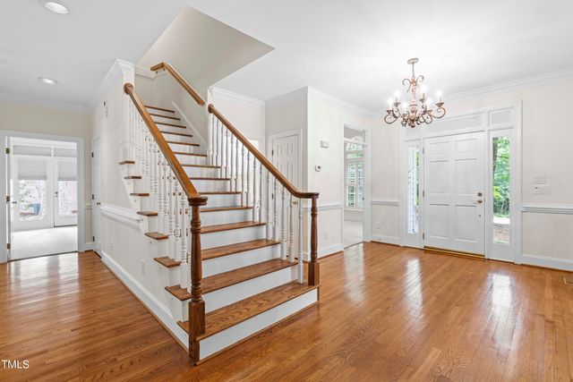 a view of a hallway with stairs and wooden floor