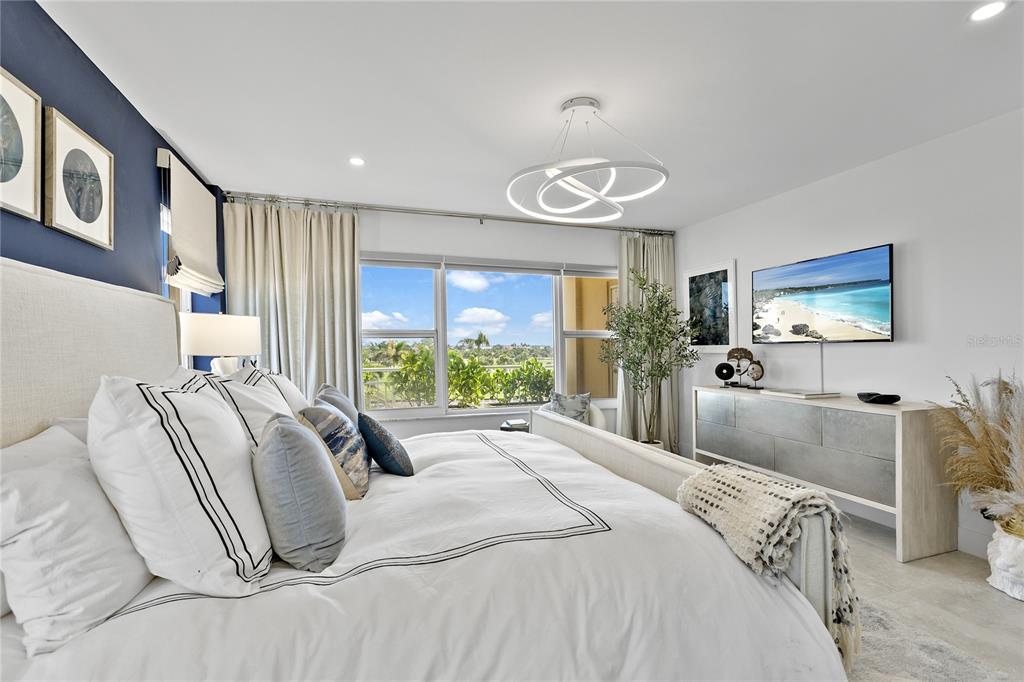 601 Longboat Club Road, Unit 404S Longboat Key, FL 34228 - Photo 18 of 28 a bedroom with a large bed and a flat screen tv