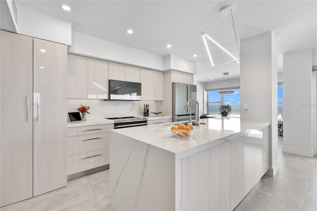 601 Longboat Club Road, Unit 404S Longboat Key, FL 34228 - Photo 5 of 28 a kitchen with white cabinets and stainless steel appliances