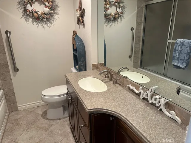 a bathroom with a granite countertop sink a toilet and a mirror