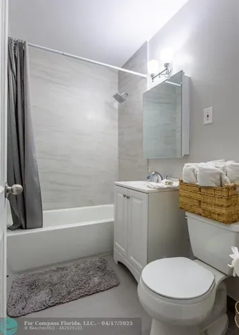 a white toilet sitting next to a bath tub and a shower