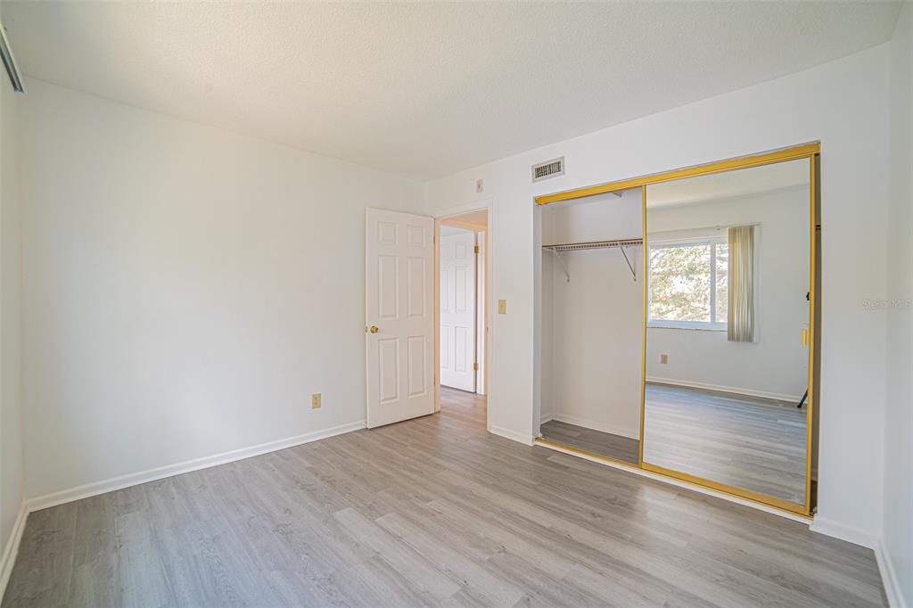 629 North Keene Road, Unit T11 Clearwater, FL 33755 - Photo 13 of 16 an empty room with wooden floor and windows