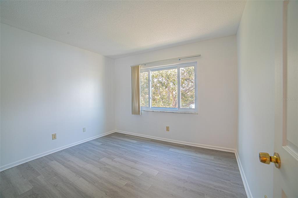629 North Keene Road, Unit T11 Clearwater, FL 33755 - Photo 14 of 16 an empty room with wooden floor and windows